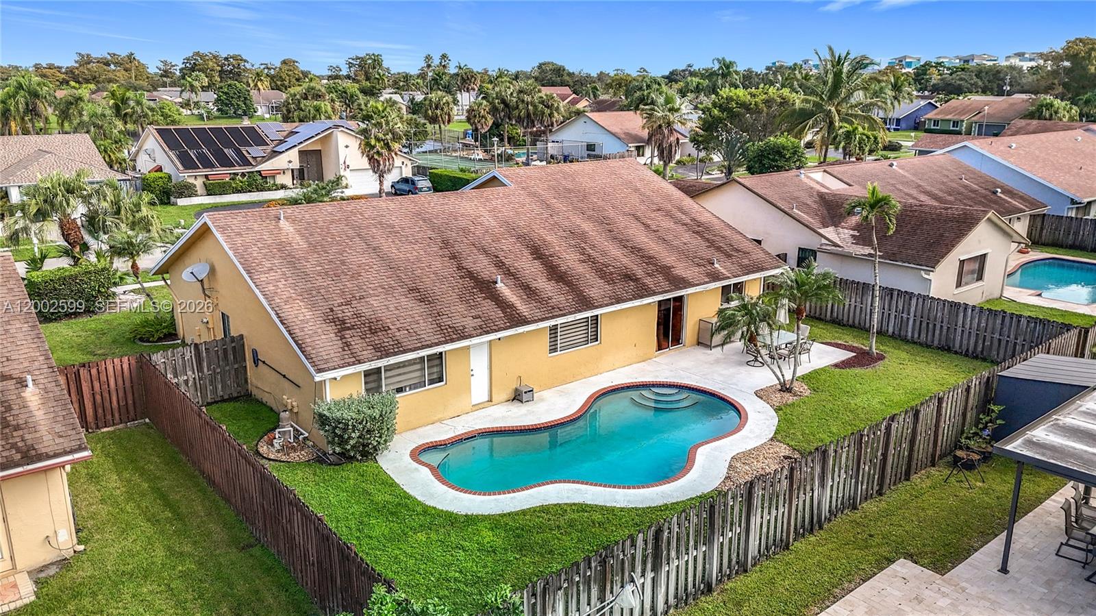 An aerial view shows a yellow house with a brown roof and a kidney-shaped pool — 8060 NW 51st Ct # 8060, Lauderhill FL 33351, LAUDERHILL, FL