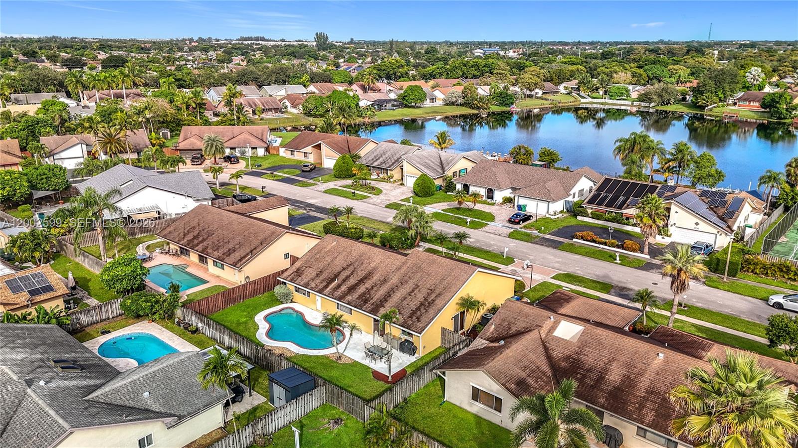 An aerial view shows suburban houses with swimming pools near a lake — 8060 NW 51st Ct # 8060, Lauderhill FL 33351, LAUDERHILL, FL