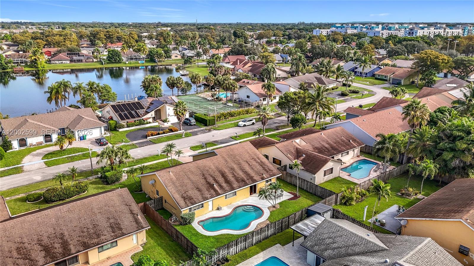An aerial view of a suburban neighborhood featuring houses with swimming pools and a lake — 8060 NW 51st Ct # 8060, Lauderhill FL 33351, LAUDERHILL, FL