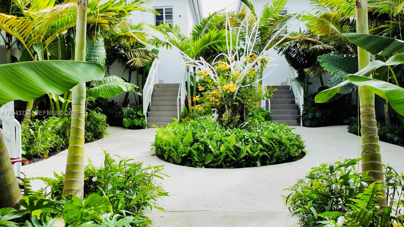 A landscaped courtyard features a central circular garden bed between two outdoor staircases — 8035 Abbott Ave, Miami Beach FL 33141, MIAMI BEACH, FL