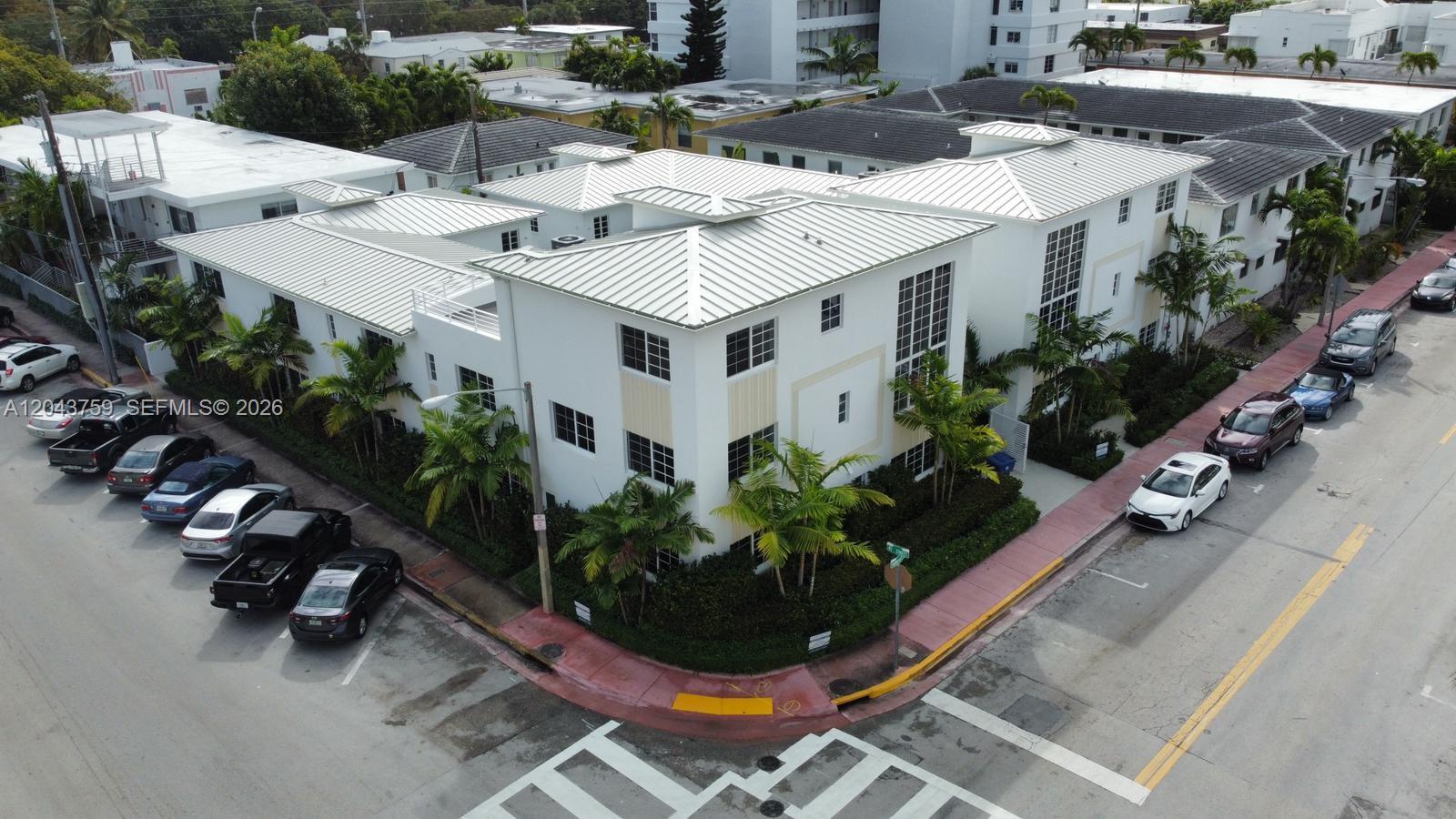 An aerial view shows a white multi-story apartment building with a metal roof and parking — 8035 Abbott Ave, Miami Beach FL 33141, MIAMI BEACH, FL