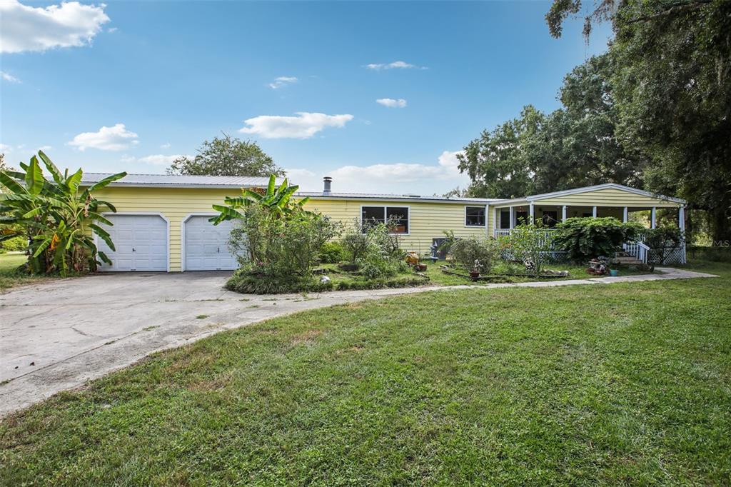 A yellow single-story house with a two-car garage, a front porch, and a grassy yard — 5321 BRUTON ROAD, PLANT CITY, FL
