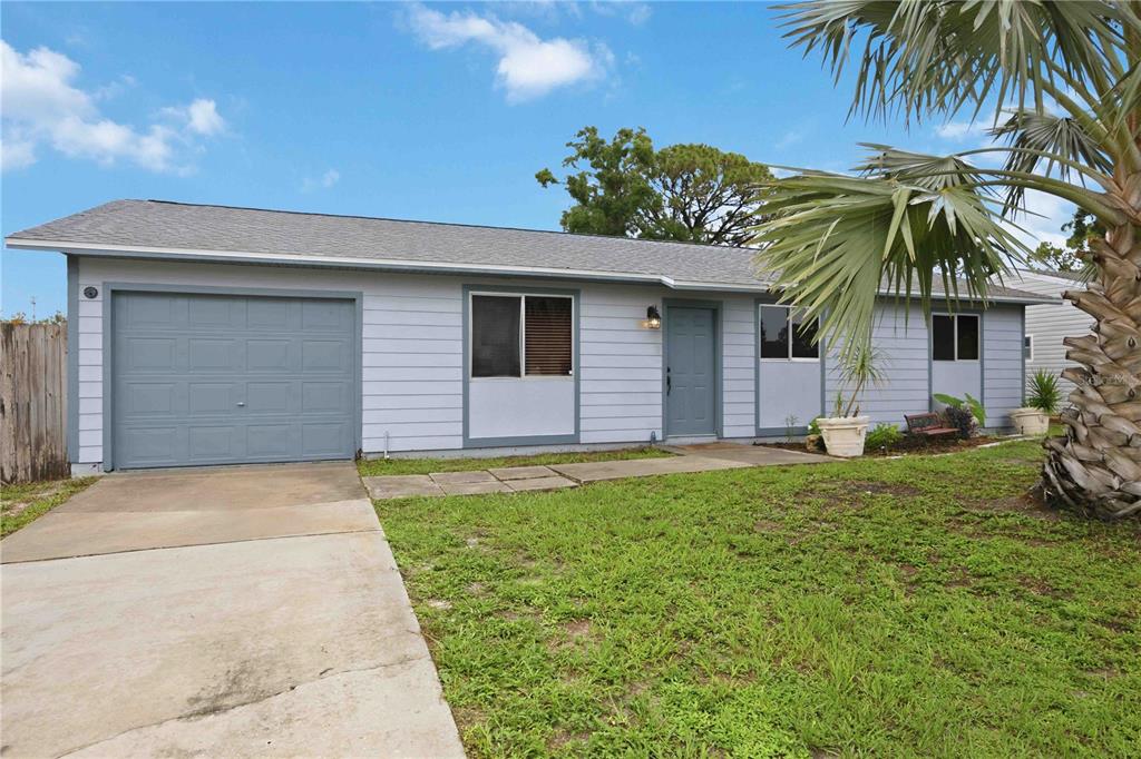 A single-story gray house with a large palm tree and a grassy front lawn — 4057 VANA DRIVE, SARASOTA, FL