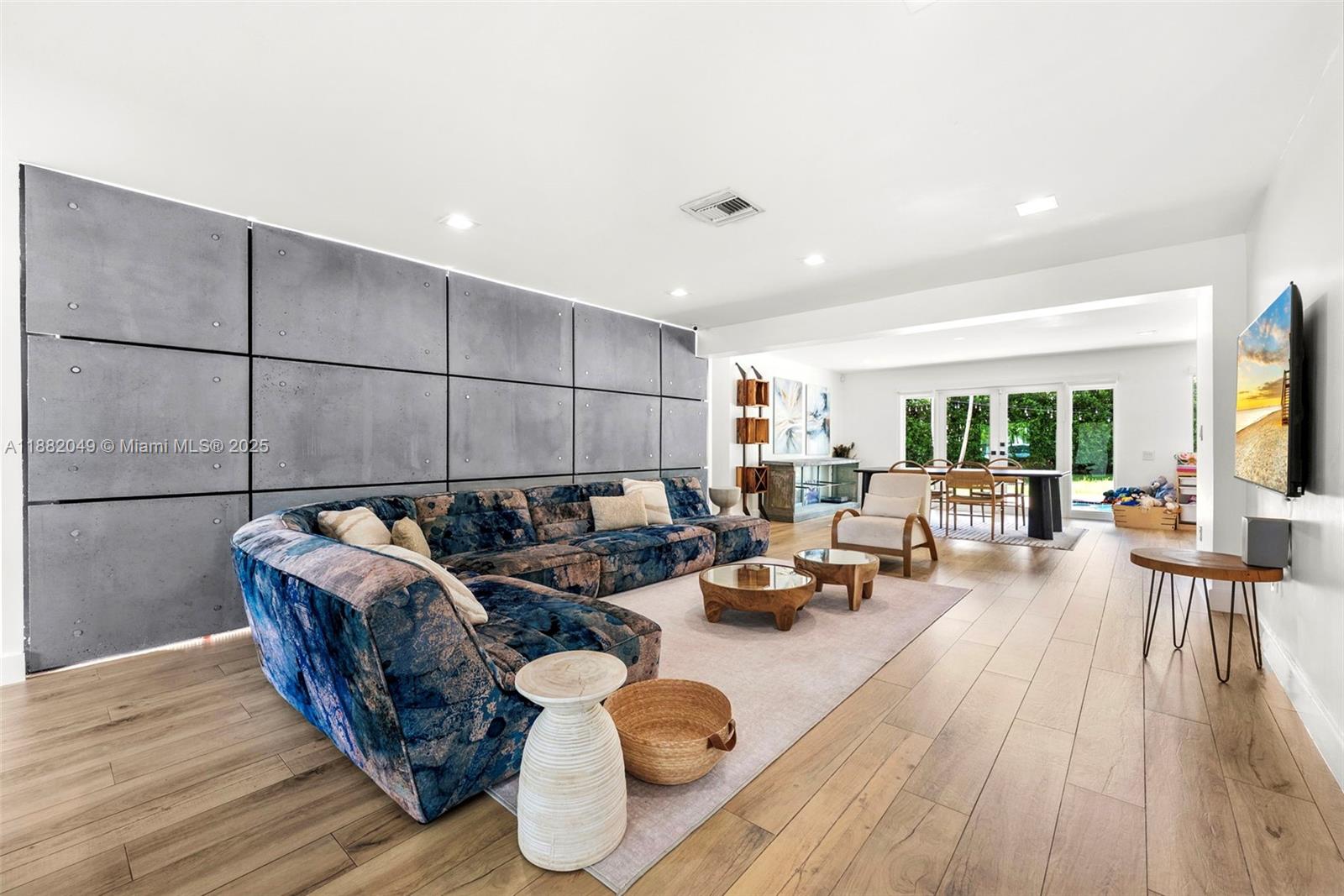 A living room features a large patterned sectional sofa against a gray paneled accent wall — 21000 NE 18th Ct, Miami FL 33179, MIAMI, FL