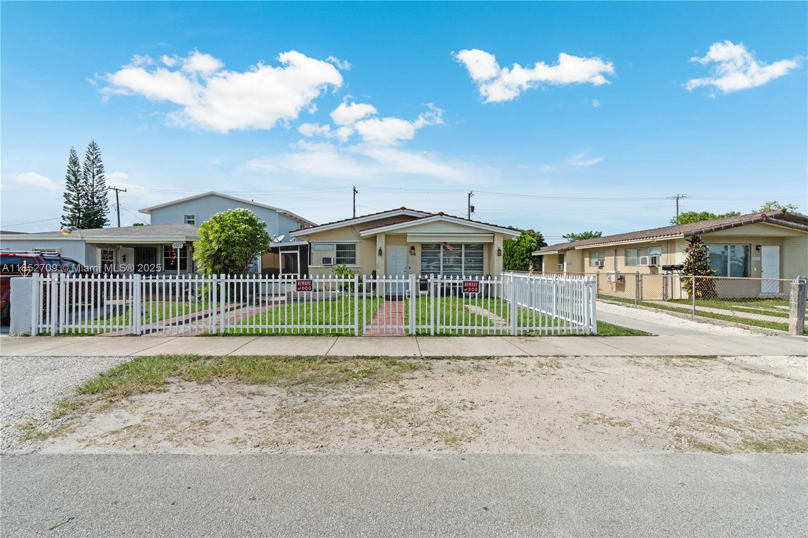 A single-story house with a white picket fence and a grassy front yard — 9311 SW 37th St, Miami FL 33165, MIAMI, FL