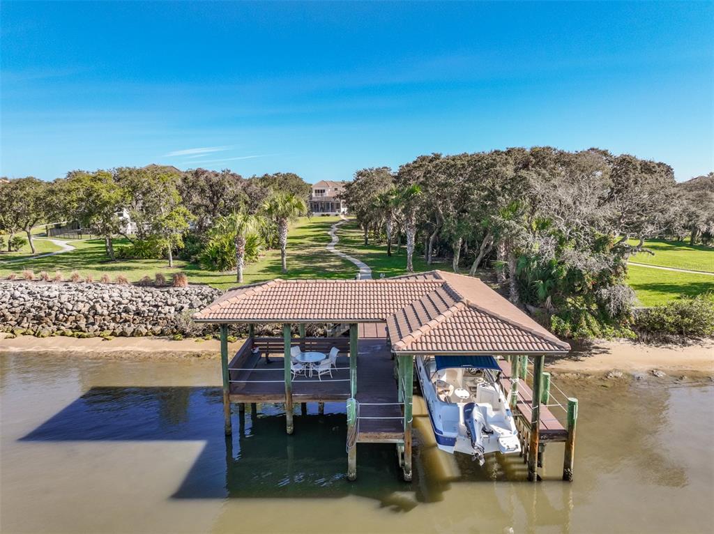 An aerial view shows a covered boat dock with a boat and seating area — 104 ISLAND ESTATES PARKWAY, PALM COAST, FL