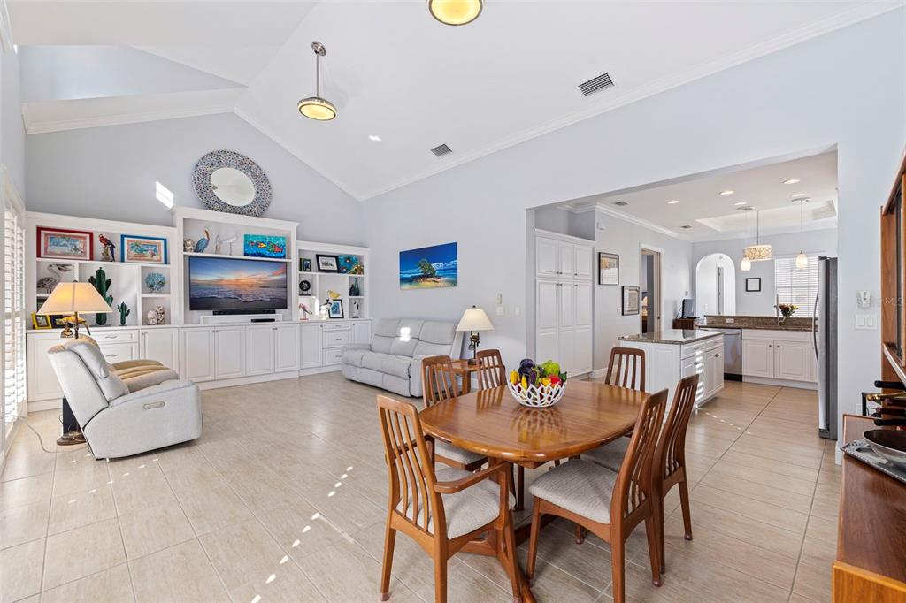 An open-concept living and dining area with vaulted ceilings, tile floors, and white cabinetry — 6101 YEATS MANOR DRIVE, TAMPA, FL