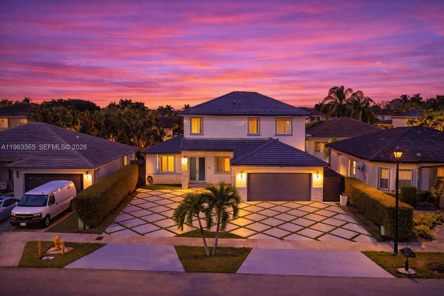 A two-story suburban house features a diamond-patterned driveway and a vibrant sunset sky — 15967 SW 141st St, Miami FL 33196, MIAMI, FL