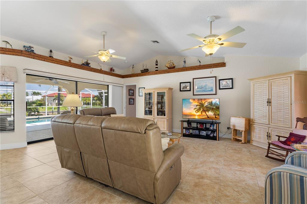 A living room features tile floors, vaulted ceilings with two fans, and a sliding glass door — 1374 WILLET COURT, PUNTA GORDA, FL