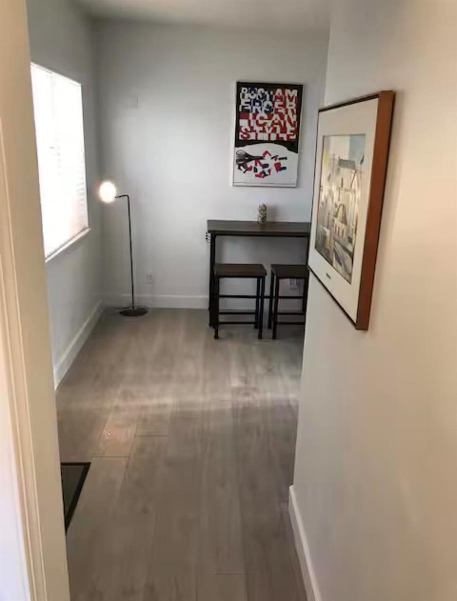 A small dining area features light wood-look flooring, a tall table with two stools, and artwork — 41 NE 1st Avenue # 4, Dania Beach FL 33004, DANIA BEACH, FL