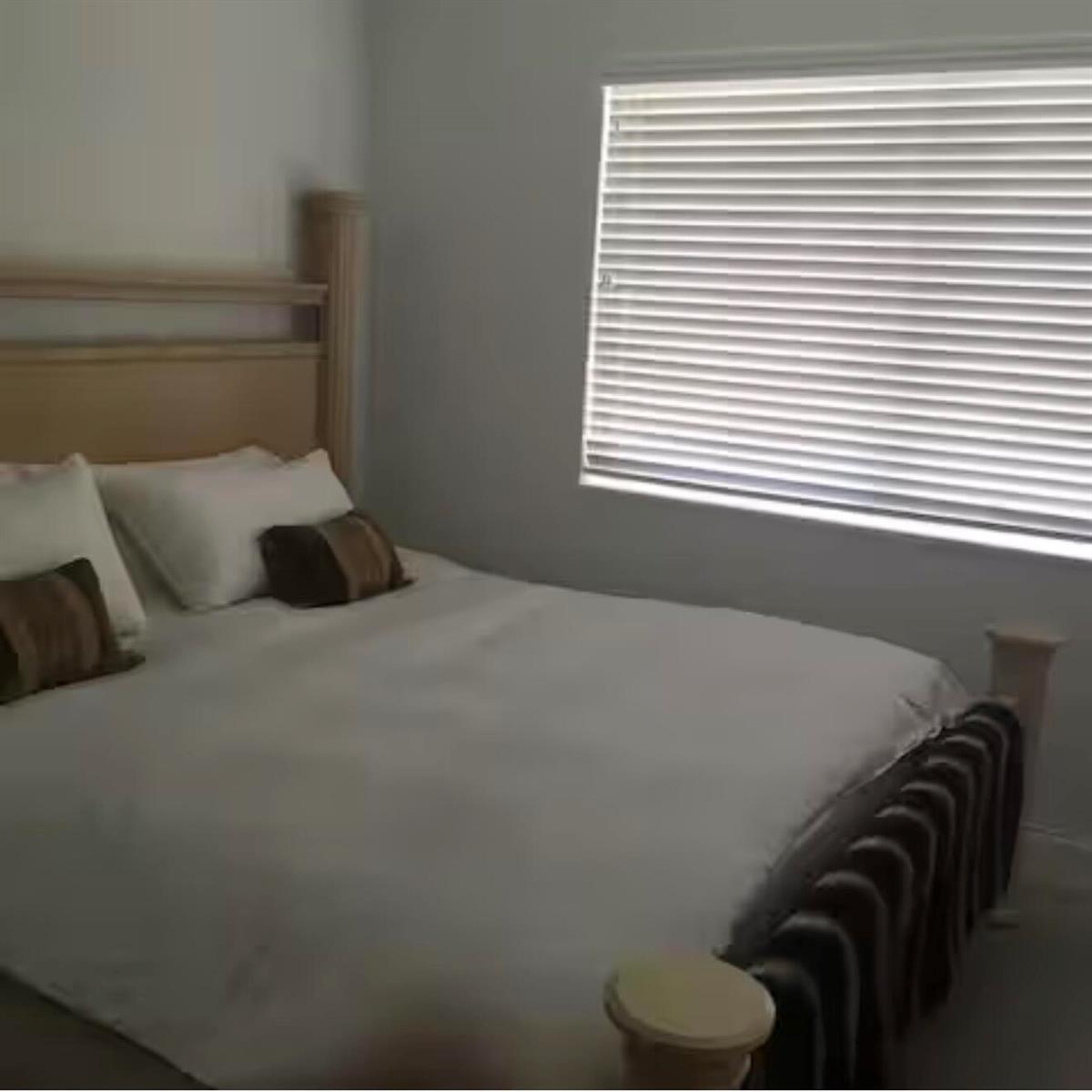 A bedroom features a light wood bed frame, white bedding, and a window with blinds — 41 NE 1st Avenue # 4, Dania Beach FL 33004, DANIA BEACH, FL