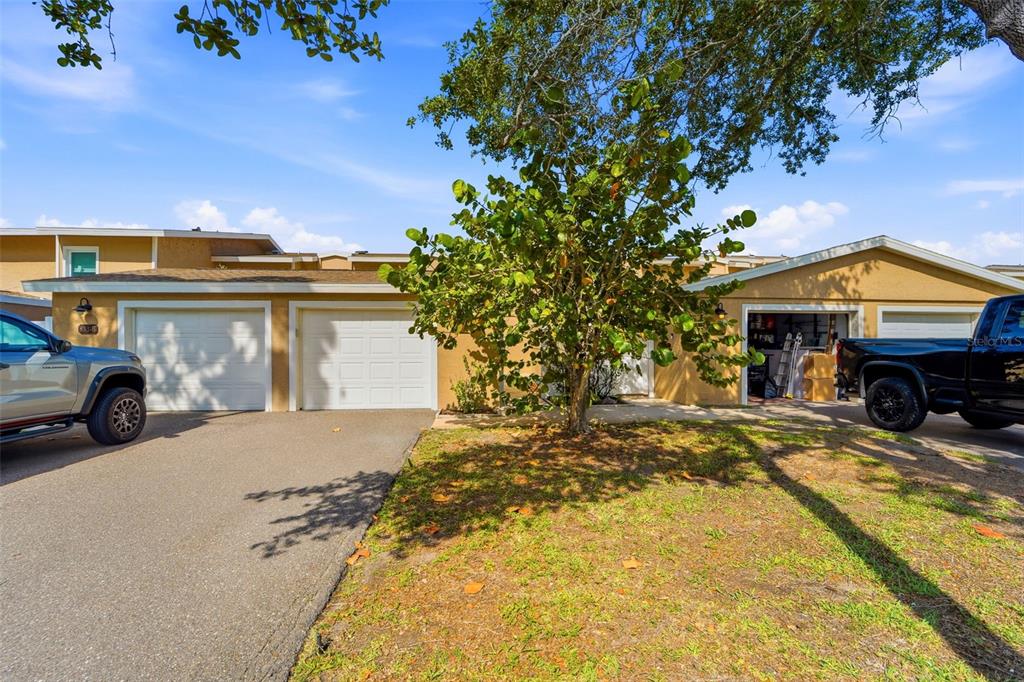 An aerial view shows a coastal residential community with townhomes, docks, and surrounding waterways — 833 E GULF BOULEVARD UNIT 103, INDIAN ROCKS BEACH, FL