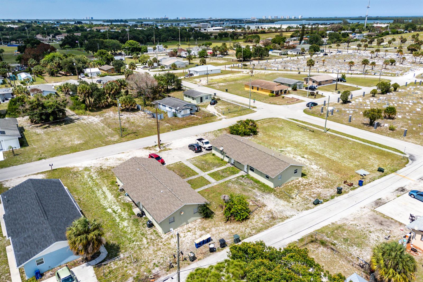 An aerial view shows two single-story residential buildings with brown roofs surrounded by sandy lots — 1205 Ave K, Fort Pierce FL 34950, FORT PIERCE, FL
