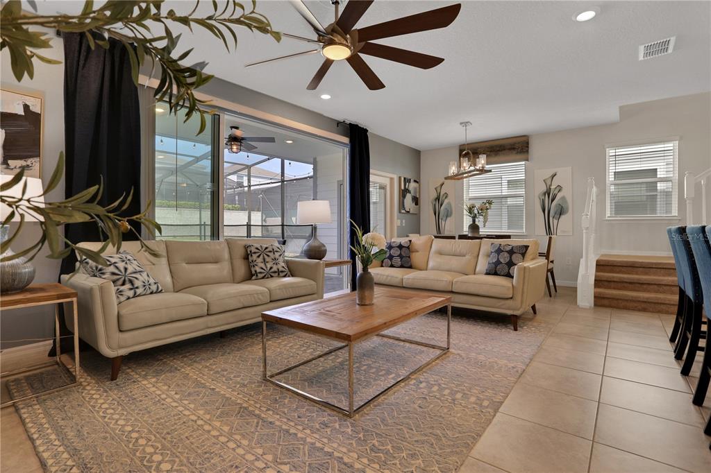 A living room with light-colored sofas, a wooden coffee table, and a ceiling fan — 900 PARADISE DRIVE, DAVENPORT, FL