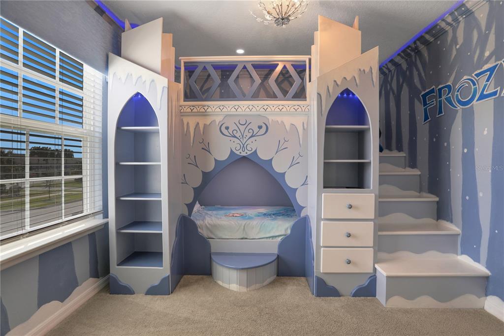 A child's bedroom features a custom Frozen-themed castle bunk bed with built-in shelves and stairs — 900 PARADISE DRIVE, DAVENPORT, FL