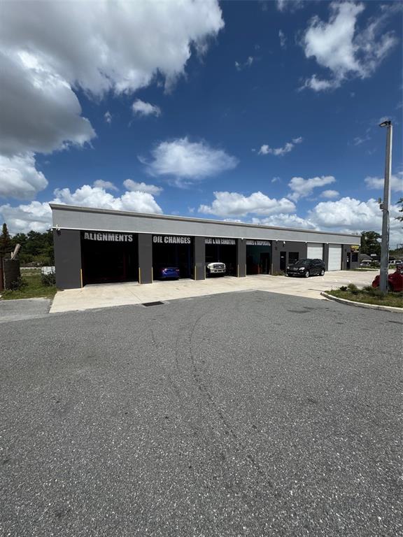 An exterior view of a commercial auto repair shop with multiple service bays — 4825 OLD WINTER GARDEN ROAD, ORLANDO, FL