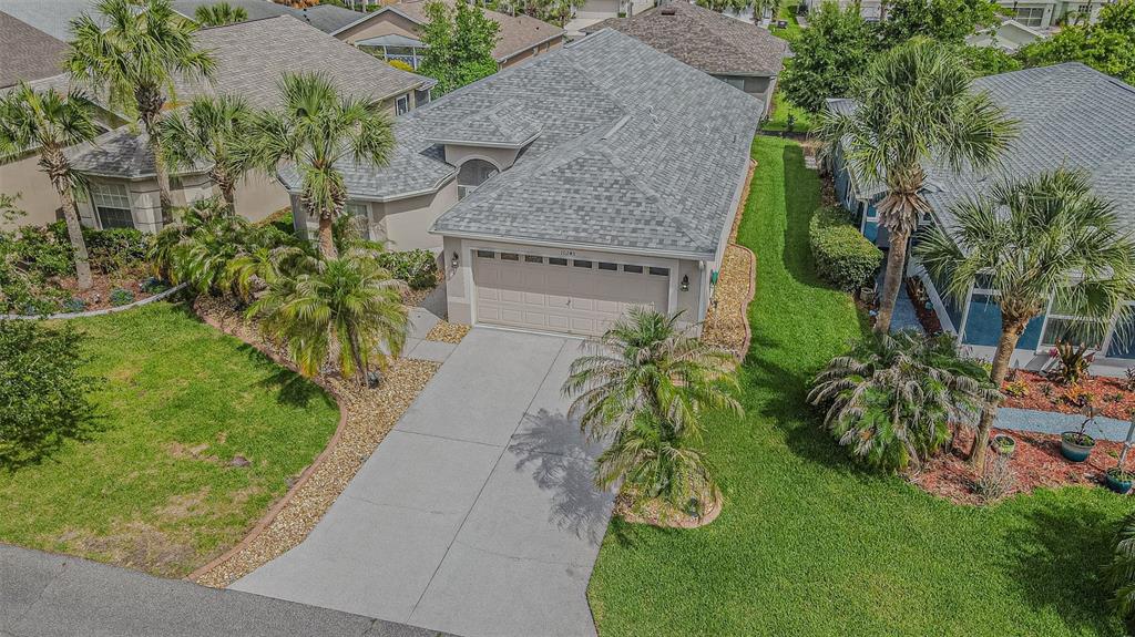 An aerial view of a single-story suburban house with a gray roof and concrete driveway — 10245 BUNCOMBE WAY, SAN ANTONIO, FL