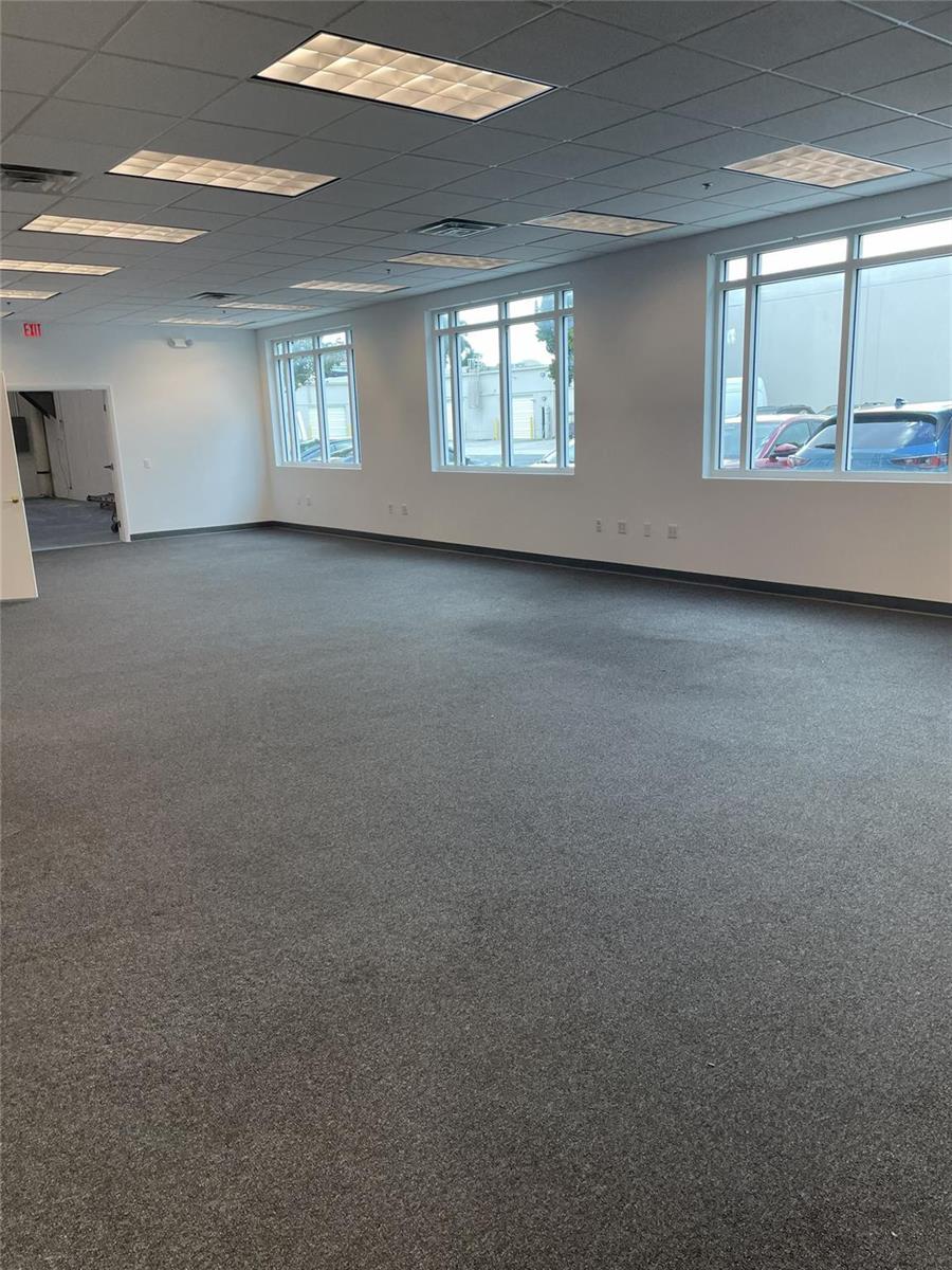 An empty office space with gray carpeting, white walls, and multiple windows — FORT LAUDERDALE, FL