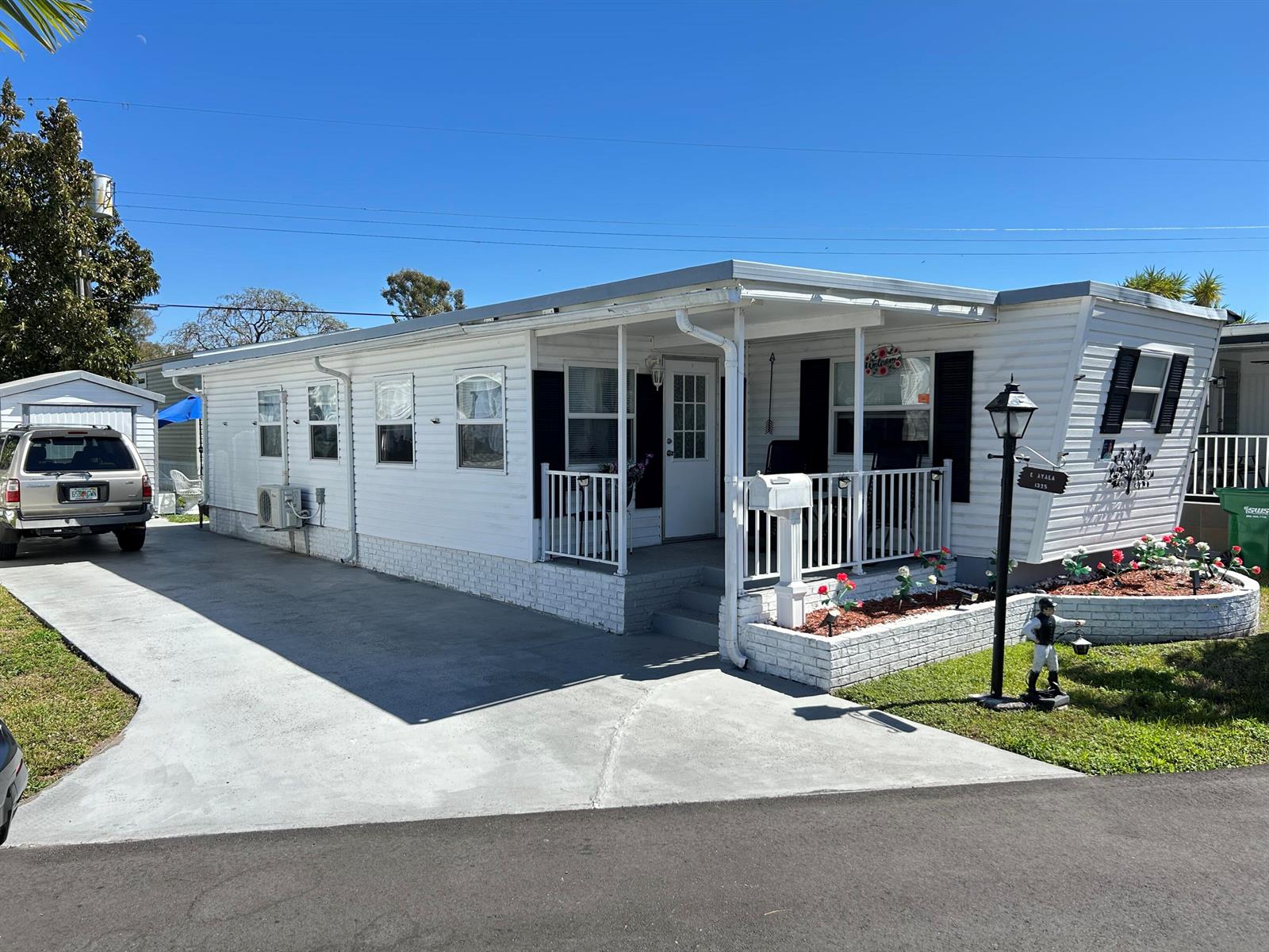 A white mobile home with a covered front porch, concrete driveway, and a small yard — 1325 S 33 Road, Hollywood FL 33021, HOLLYWOOD, FL