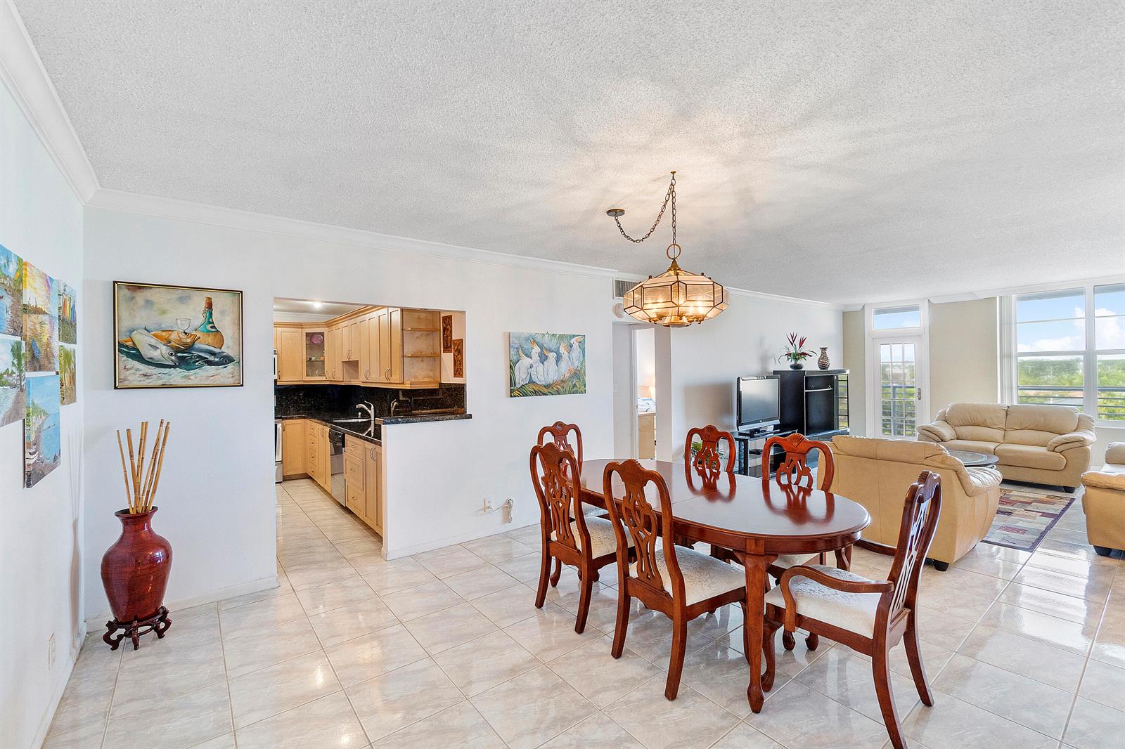 A dining area with a wooden table and chairs sits adjacent to an open kitchen — 2851 S Ocean Boulevard # B, Boca Raton FL 33432, BOCA RATON, FL