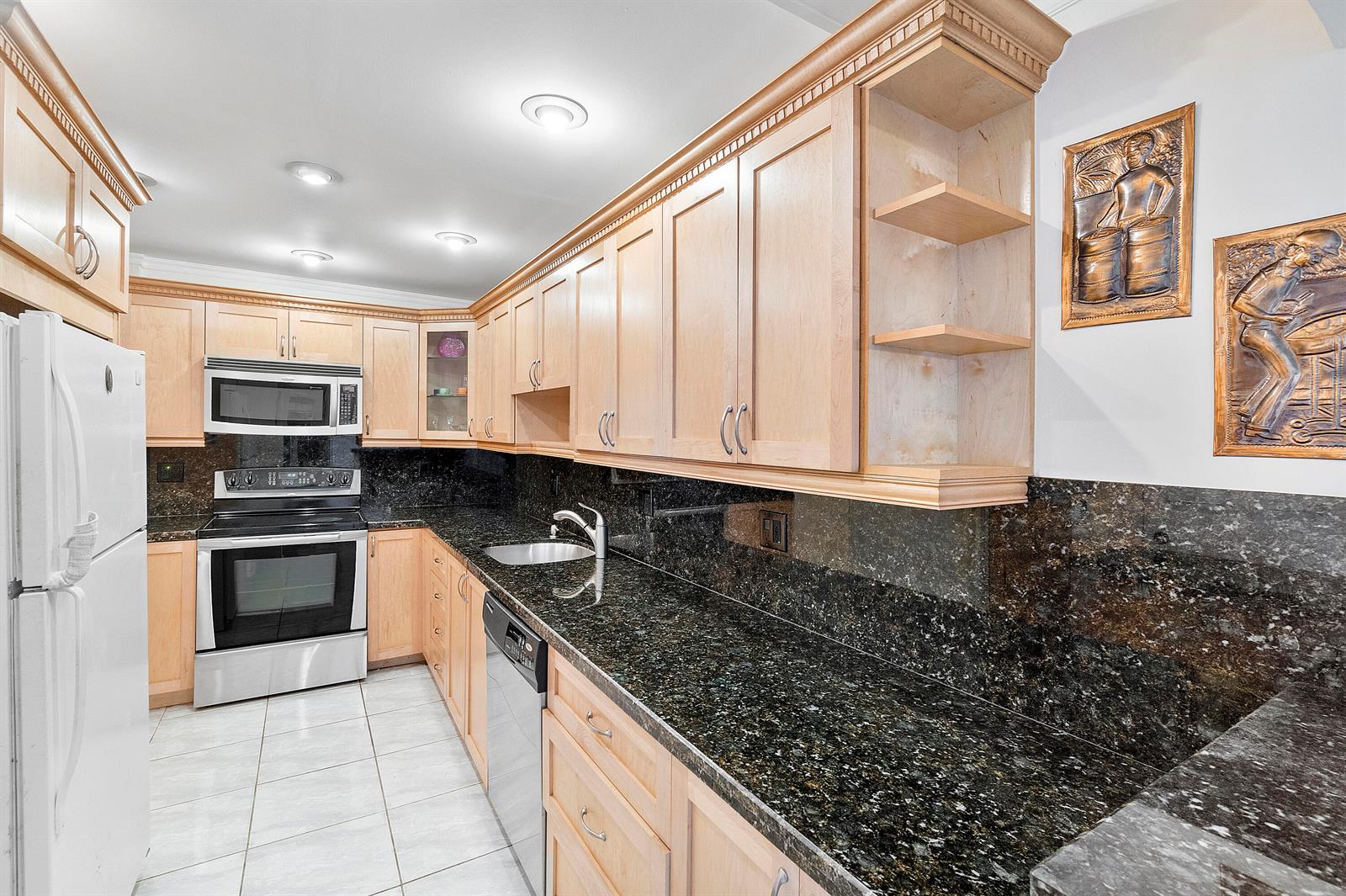 A kitchen features light wood cabinets, dark granite countertops, stainless steel appliances, and tile flooring — 2851 S Ocean Boulevard # B, Boca Raton FL 33432, BOCA RATON, FL