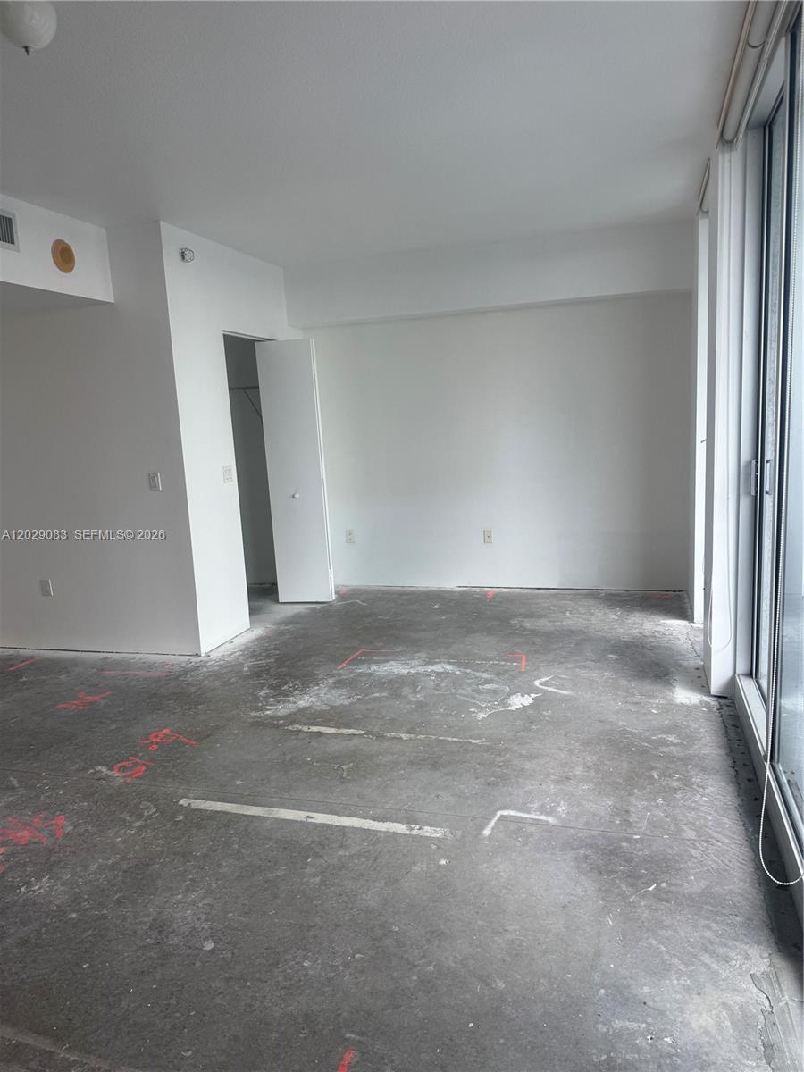 An empty room features white walls, a closet, and an unfinished concrete floor — 185 SW 7th St # 3900, Miami FL 33130, MIAMI, FL