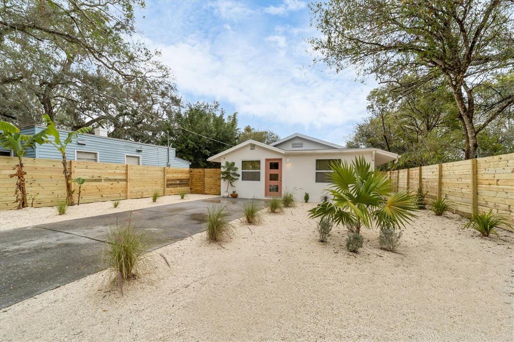A living room features white walls, yellow curtains, a television, and modern furniture — 2441 NOVUS STREET, SARASOTA, FL