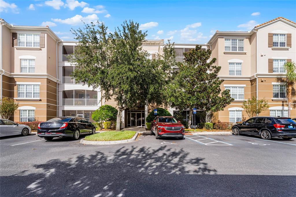 A three-story apartment building with a parking lot and trees in front — 3356 ROBERT TRENT JONES DRIVE UNIT 101, ORLANDO, FL