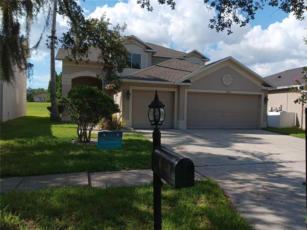 A two-story suburban house with a three-car garage and a front yard mailbox — 18178 SANDY POINTE DRIVE, TAMPA, FL