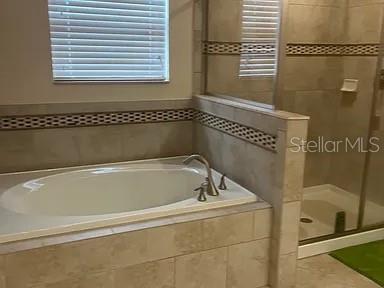 A bathroom features a tiled soaking tub and a separate glass-enclosed shower stall — 4309 SUMMER BREEZE WAY, KISSIMMEE, FL
