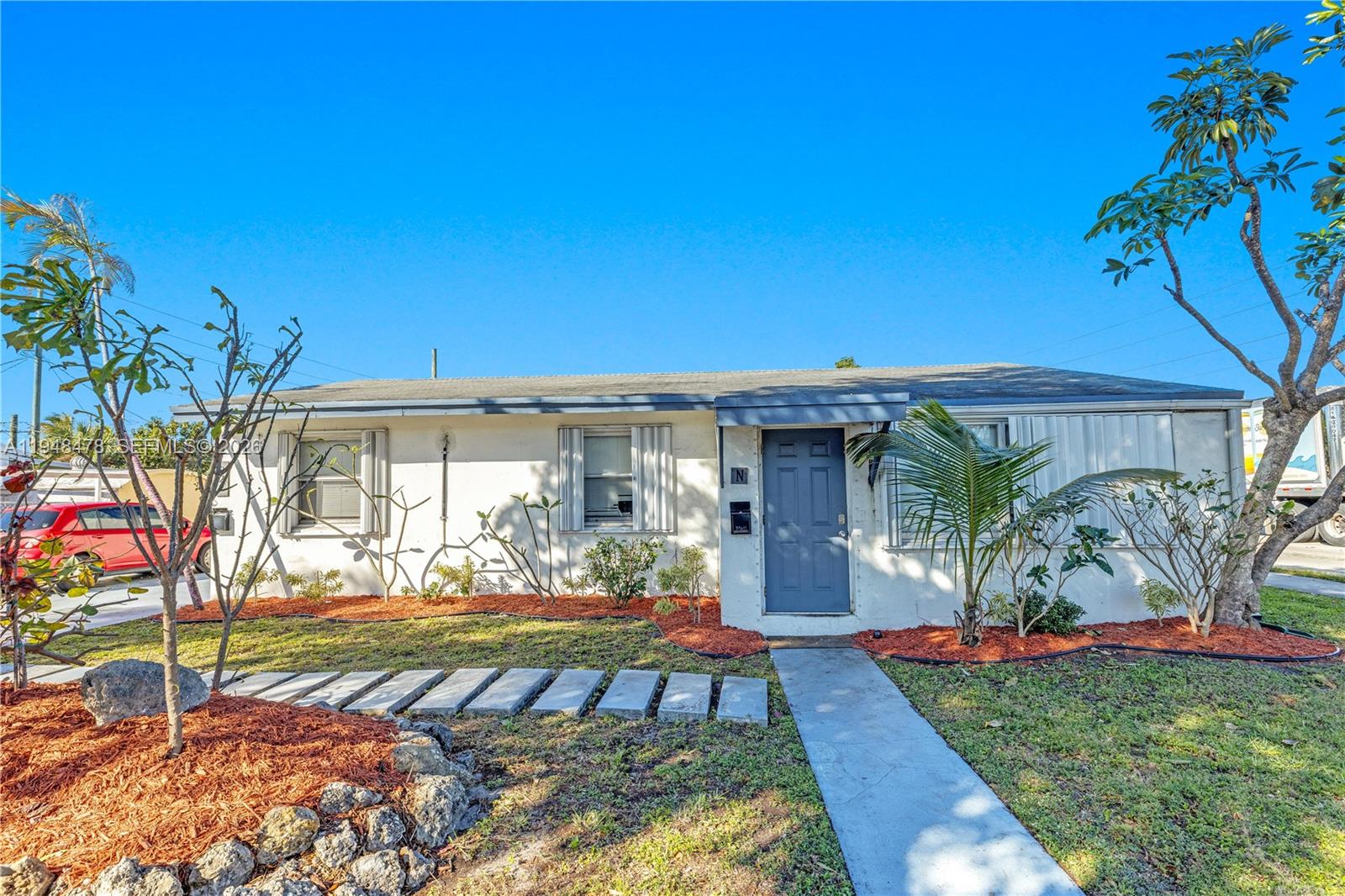 A single-story white house with a blue front door and a concrete walkway — 822 N 20th Ave, Hollywood FL 33020, HOLLYWOOD, FL