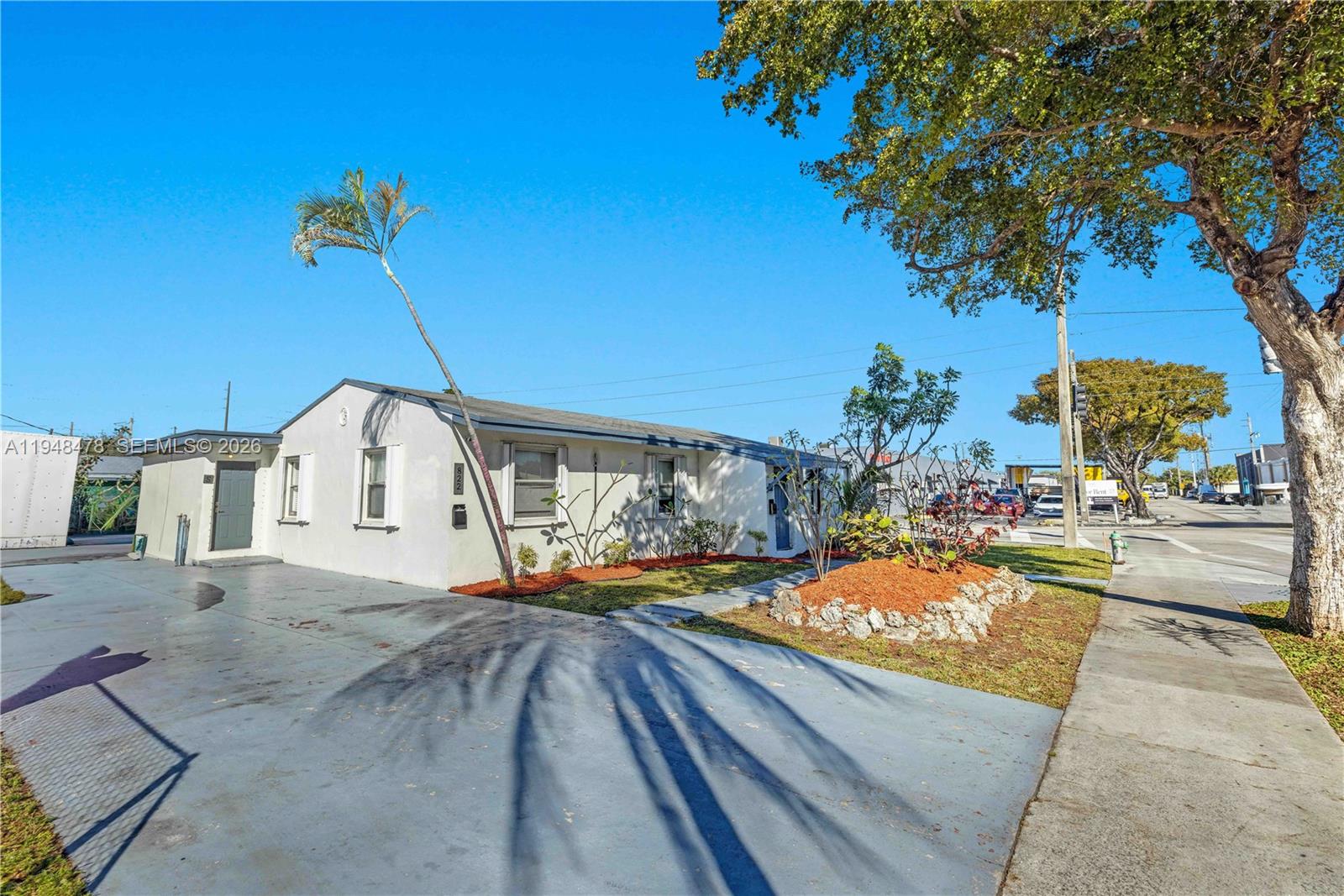 A single-story white house with a paved driveway and a palm tree in the front yard — 822 N 20th Ave, Hollywood FL 33020, HOLLYWOOD, FL