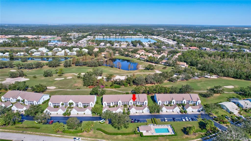 An aerial view shows a residential complex with a swimming pool and a golf course — 6713 STONE RIVER ROAD UNIT 205, BRADENTON, FL