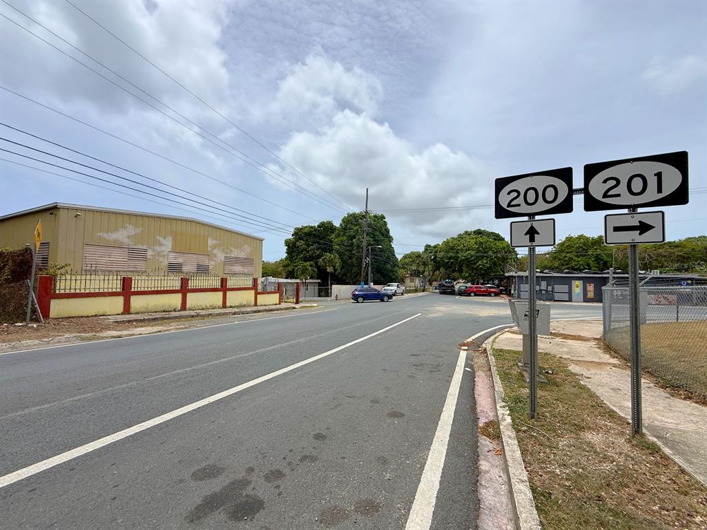 A paved road leads to an intersection with road signs for routes 200 and 201 — KM 1.6 ROUTE 200, VIEQUES, PR