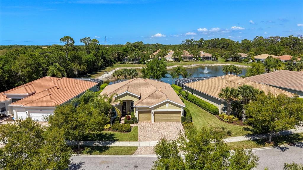 An aerial view shows a suburban house with a tan tile roof and paved driveway — 6124 ABACO DRIVE, SARASOTA, FL