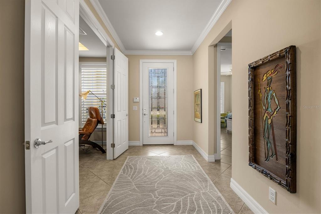 A tiled entryway features a white front door with glass panels and a decorative wall hanging — 6124 ABACO DRIVE, SARASOTA, FL