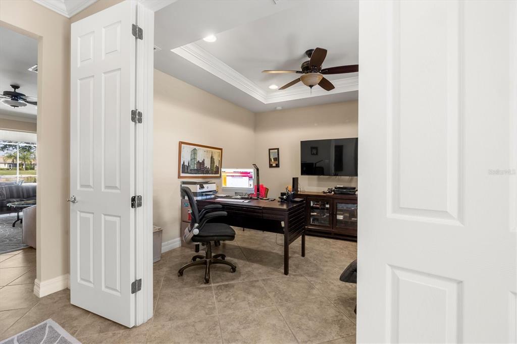 A home office with tile flooring, a dark wood desk, and a ceiling fan — 6124 ABACO DRIVE, SARASOTA, FL