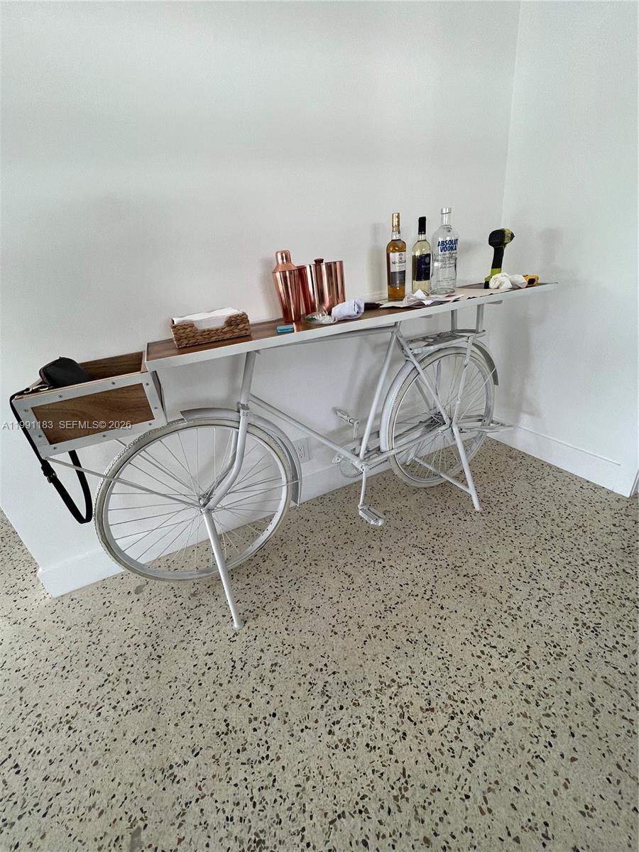 A white bicycle-themed console table with a wooden top stands against a white wall — 750 Polk St, Hollywood FL 33019, HOLLYWOOD, FL