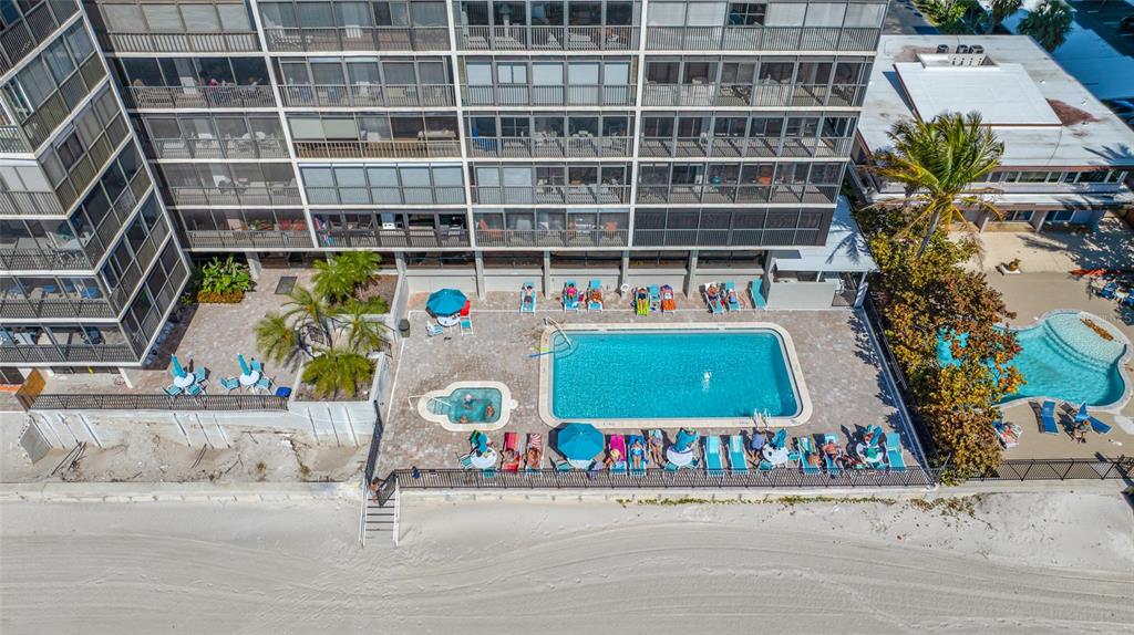 An aerial view of a beachfront apartment building with a swimming pool and hot tub — 15462 GULF BOULEVARD UNIT 603, MADEIRA BEACH, FL