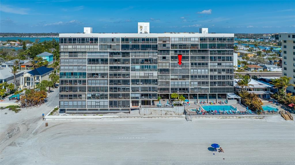 An aerial view of a multi-story beachfront condominium building with a pool and sandy beach — 15462 GULF BOULEVARD UNIT 603, MADEIRA BEACH, FL