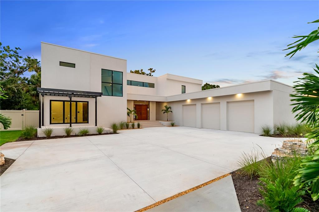 An aerial view of a modern, two-story white house with a flat roof and driveway — 1759 WALDEMERE STREET, SARASOTA, FL