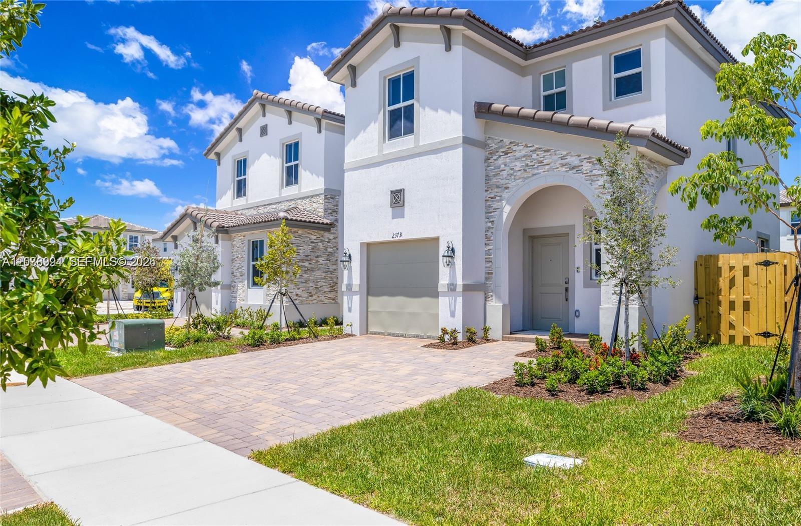 A two-story house with a white stucco facade, stone accents, and a paved driveway — 2373 NW 130th St, Miami FL 33167, MIAMI, FL