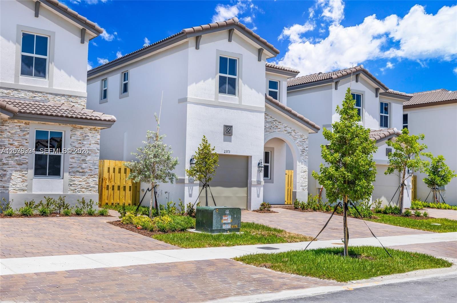 A row of modern two-story townhouses with white stucco exteriors and paved driveways — 2373 NW 130th St, Miami FL 33167, MIAMI, FL