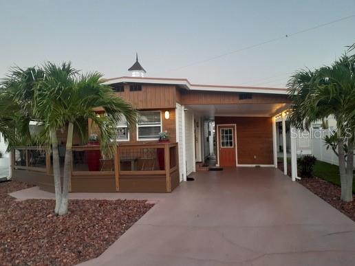 A single-story house with wood siding, a covered carport, and a front deck with railings — 2216 PENNSYLVANIA AVENUE, BRADENTON, FL