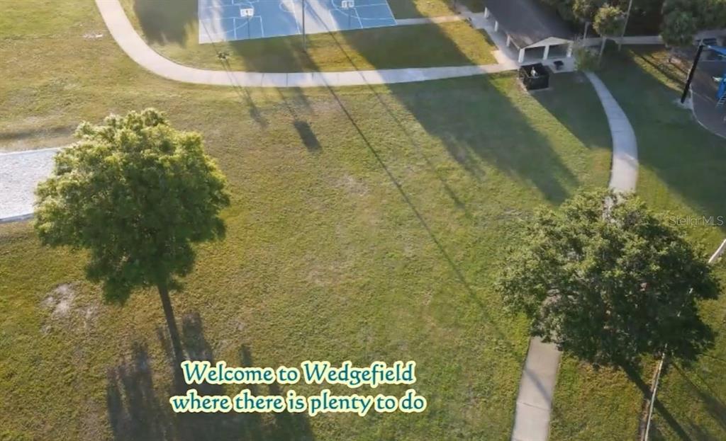 An aerial view shows a grassy park area with a basketball court and a playground — Lot 32 STARRY STREET, ORLANDO, FL
