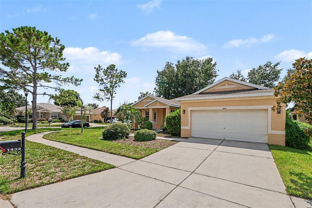 A single-story house with a beige exterior, a two-car garage, and a concrete driveway — 11432 LAUREL BROOK COURT, RIVERVIEW, FL
