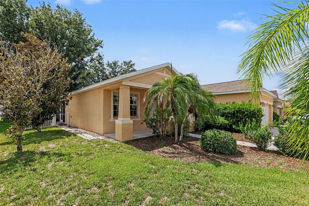A tan single-story house with a covered front porch and a palm tree in front — 11432 LAUREL BROOK COURT, RIVERVIEW, FL