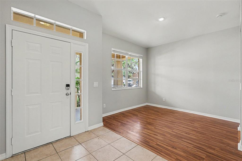 An entryway with tile flooring transitions into a living area featuring wood-look laminate flooring — 11432 LAUREL BROOK COURT, RIVERVIEW, FL