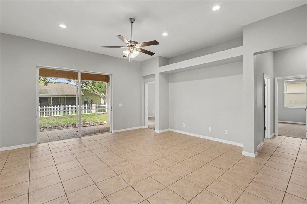 A living room with tile flooring, a ceiling fan, and sliding glass doors to a yard — 11432 LAUREL BROOK COURT, RIVERVIEW, FL