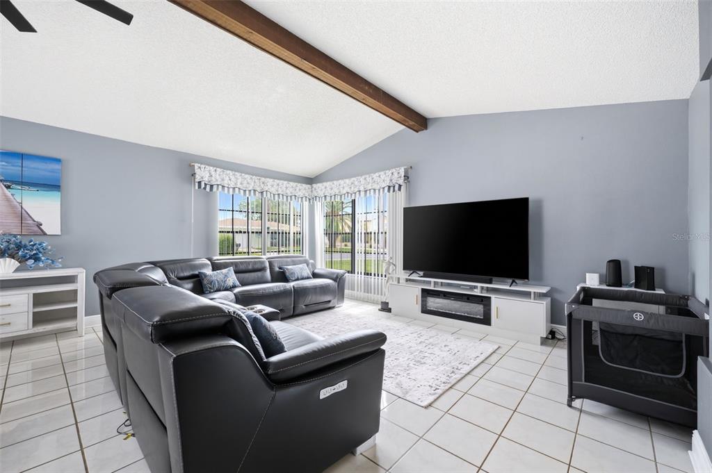A living room features a large sectional sofa, a television on a media console, and tile flooring — 4262 PARADISE CIRCLE, HERNANDO BEACH, FL